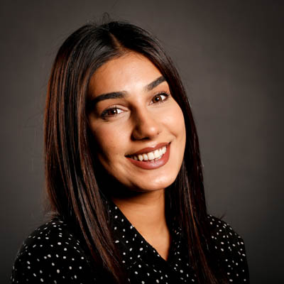 female business woman headshot wearing a black spotted blouse