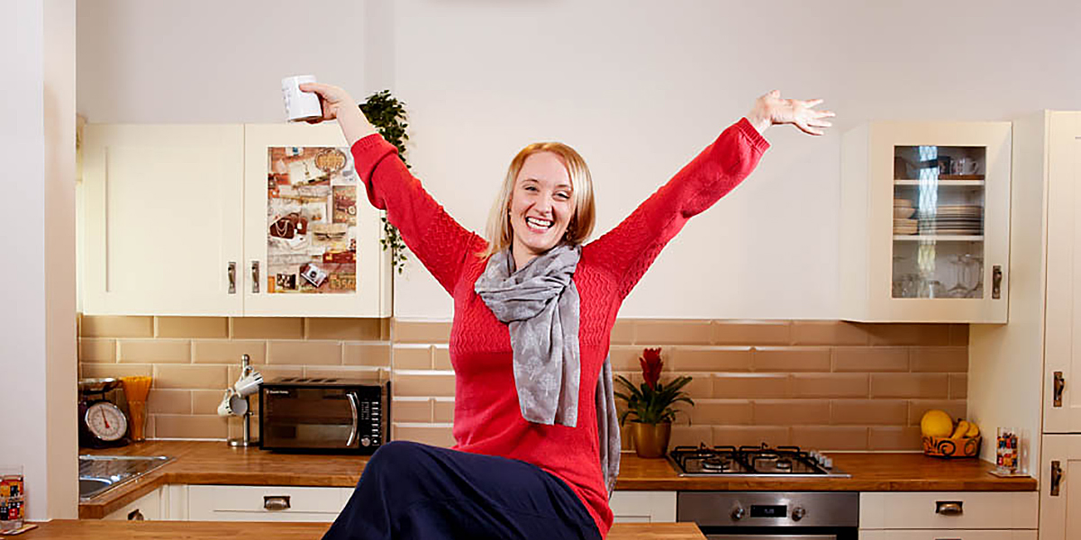 Celebrating property business woman in kitchen